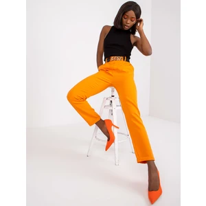 Bright orange suit trousers with a decorative Seville belt