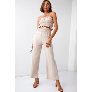 A set of women's wide trousers with a short pressed top of beige color